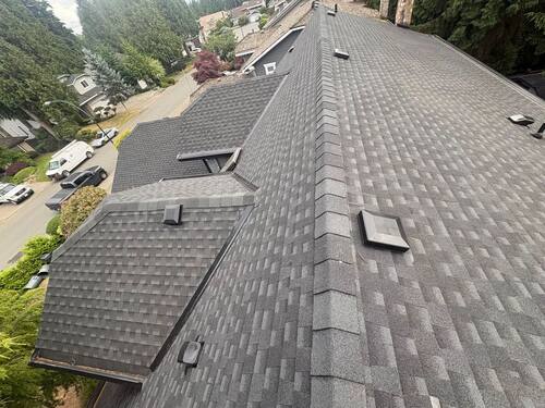 Full Roof Replacement — Close-up of the new grey architectural shingle course and ridge line.